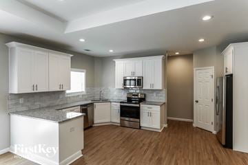Dacula house for rent - A kitchen with white cabinets and a refrigerator.