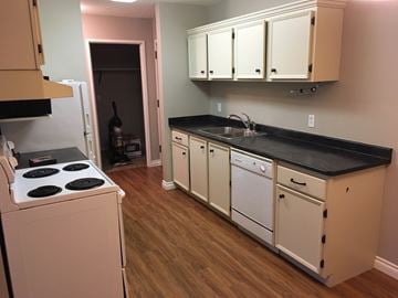 Prince Albert house for rent - a kitchen with white cabinets and a stove and a sink