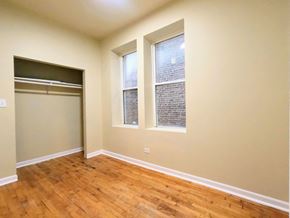 Chicago apartment for rent - a room with wood flooring and three windows and a closet