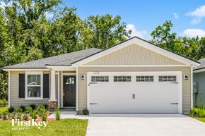 Jacksonville house for rent - a white house with a garage door and a lawn