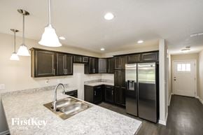 Jacksonville house for rent - a kitchen with black cabinets and a stainless steel refrigerator
