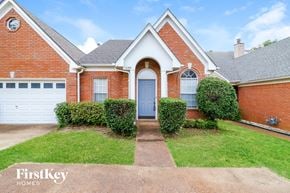 Memphis house for rent - a brick house with a blue door and a lawn