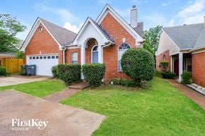 Memphis house for rent - the front of a brick house with a lawn and a driveway