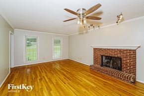 Alabaster house for rent - A room with a fireplace and a ceiling fan.