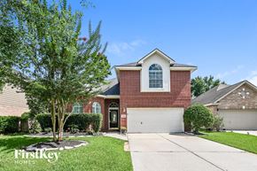 Humble house for rent - A house with a red brick facade and a white garage door is for sale.