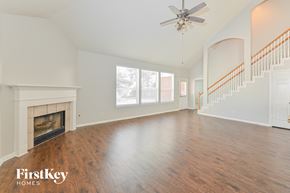 Humble house for rent - A spacious living room with a fireplace and a staircase.