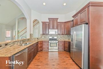 Humble house for rent - A kitchen with wooden cabinets and a stainless steel refrigerator.