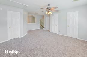 Humble house for rent - A spacious room with a ceiling fan and carpeted floor.