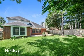 Humble house for rent - A house with a green lawn and trees in the background.