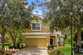 Orange Park house for rent - a yellow house with a yellow garage door and trees