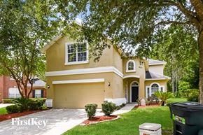 Orange Park house for rent - a beige house with a lawn and trees
