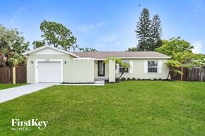 Apollo Beach house for rent - a small white house with a lawn and a garage
