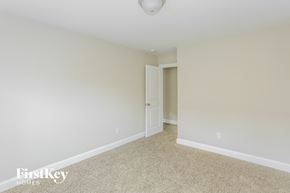 Kannapolis house for rent - a bedroom with white walls and carpet and a door to a closet