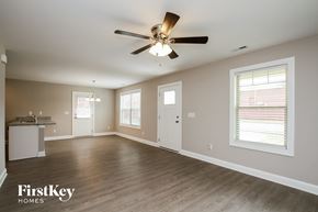 Kannapolis house for rent - an empty living room with a ceiling fan and a kitchen