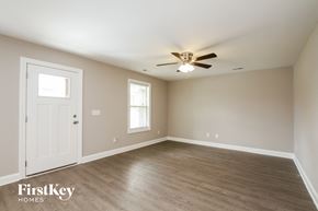 Kannapolis house for rent - a bedroom with a ceiling fan and a white door