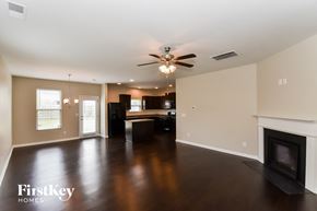 Atlanta house for rent - A spacious living room with a fireplace and a ceiling fan.