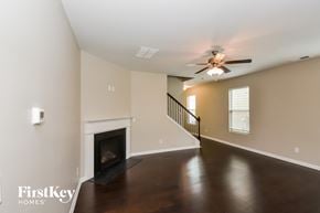 Atlanta house for rent - A spacious room with a fireplace and a staircase.