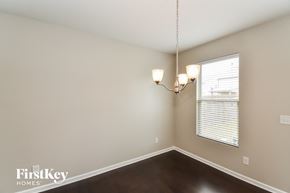 Atlanta house for rent - A room with a chandelier and a window with blinds.