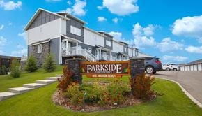 Saskatoon apartment for rent - A sign for Parkside Townhomes stands in front of a building.