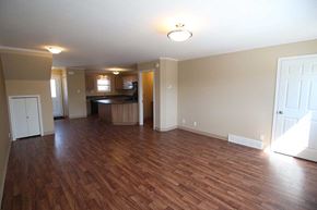 Saskatoon apartment for rent - A room with wooden floors and a white door.