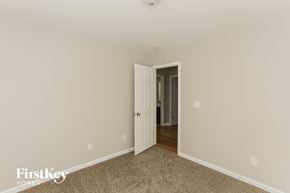 Kannapolis house for rent - a bedroom with beige carpet and a door to a hallway