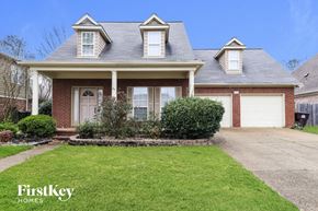 Collierville house for rent - the front of a brick house with white garage doors