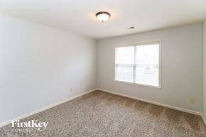 Collierville house for rent - a bedroom with a large window and a carpeted floor