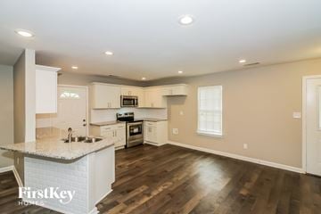 Memphis house for rent - a kitchen with white cabinets and a marble counter top
