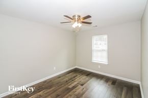 Memphis house for rent - a bedroom with hardwood flooring and a ceiling fan