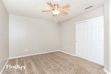 Hamilton house for rent - the spacious living room with carpet and a ceiling fan
