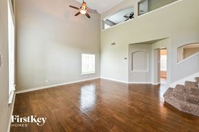 Baytown house for rent - an empty living room with wood floors and a ceiling fan