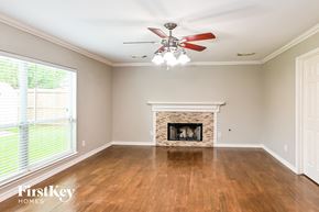 Baytown house for rent - a living room with a fireplace and a ceiling fan
