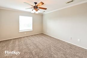 Baytown house for rent - a bedroom with carpet and a ceiling fan