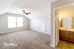 Moncks Corner house for rent - a master bedroom with a bathroom and a ceiling fan