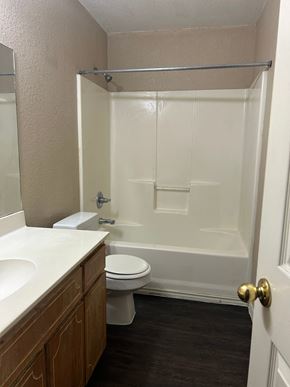 Killeen apartment for rent - A white bathroom with a toilet, sink, and shower.