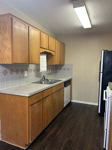 Killeen apartment for rent - A kitchen with wooden cabinets and a black refrigerator.