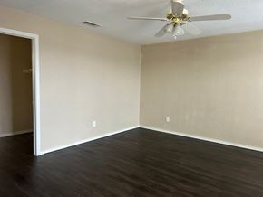 Killeen apartment for rent - Empty room with a ceiling fan and dark wood flooring.