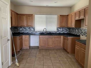 Anthem house for rent - a kitchen with wooden cabinets and tiled floors