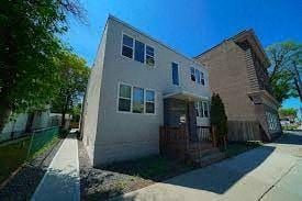 Winnipeg apartment for rent - a white house with a yard and a sidewalk