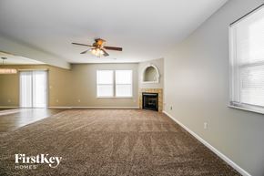 Blacklick house for rent - an empty living room with a ceiling fan and a fireplace