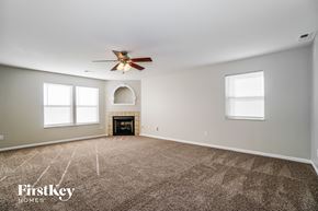 Blacklick house for rent - an empty living room with a ceiling fan and a fireplace