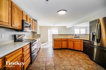 Blacklick house for rent - a kitchen with wooden cabinets and stainless steel appliances