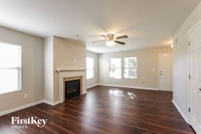 Mount Holly house for rent - A spacious room with a fireplace and wooden floors.
