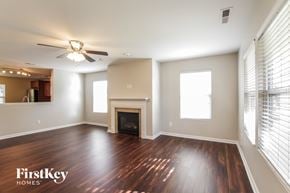 Mount Holly house for rent - A spacious living room with wood flooring and a fireplace.