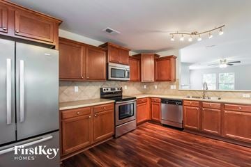 Mount Holly house for rent - A kitchen with wooden cabinets and a refrigerator.