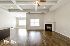 Mcdonough house for rent - A spacious living room with a fireplace and a ceiling fan.