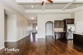 Mcdonough house for rent - A spacious kitchen with dark wood floors and a ceiling fan.