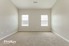 Mcdonough house for rent - A spacious room with two windows and a carpeted floor.