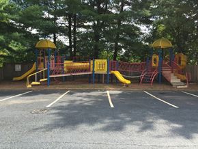 Collinsville apartment for rent - A playground with a yellow slide and red and blue structures.