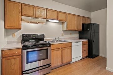 Collinsville apartment for rent - A kitchen with wooden cabinets and black appliances.